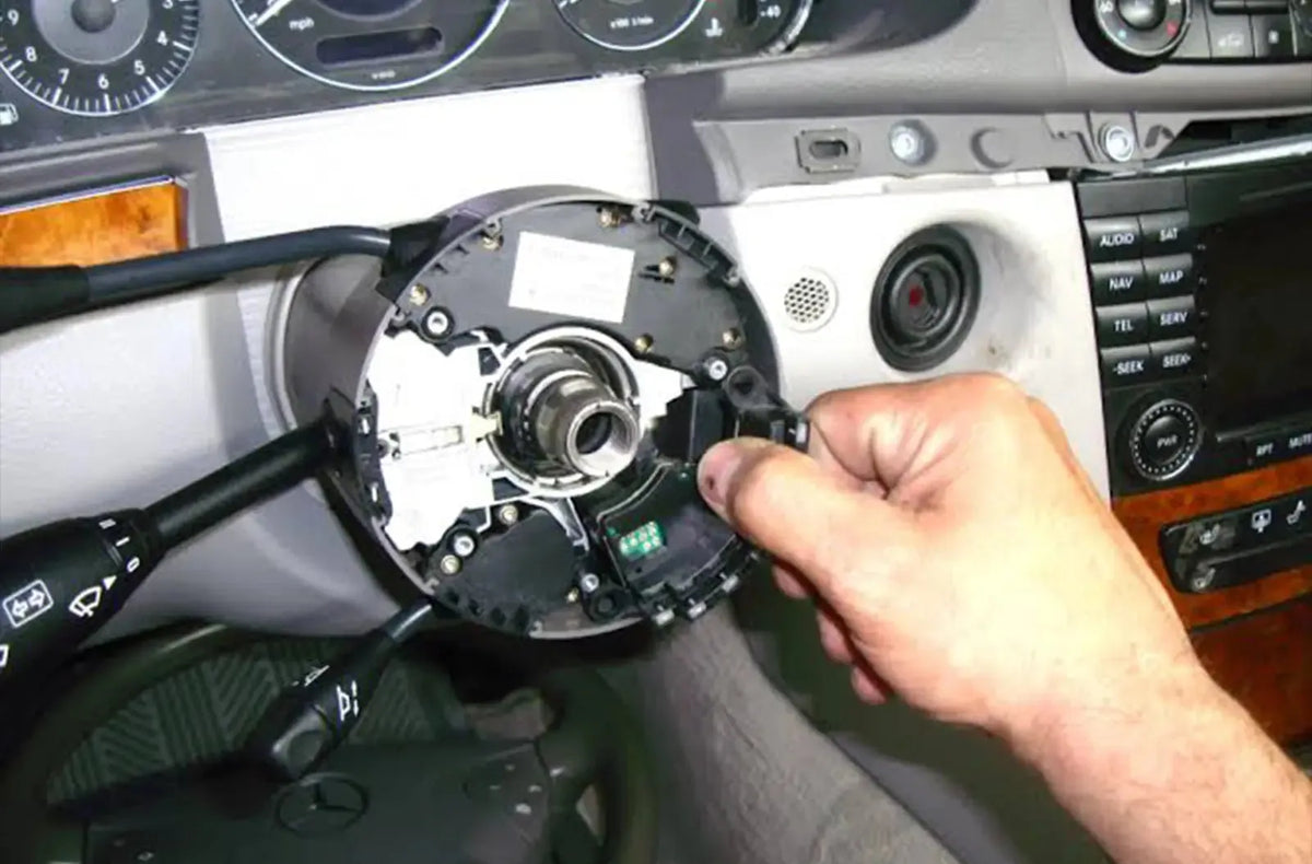 Primer plano del testigo naranja de "Control electrónico de estabilidad (ESC) / Control de tracción" iluminado en el cuadro de instrumentos oscuro de un coche.
