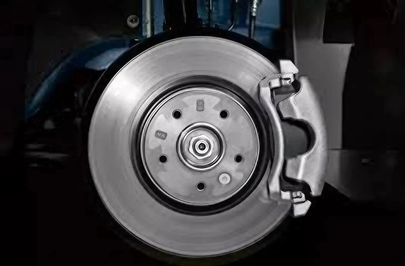 Primer plano desde el espacio reposapiés del conductor con una bota de cuero negra presionando con fuerza el pedal de freno de goma del vehículo.