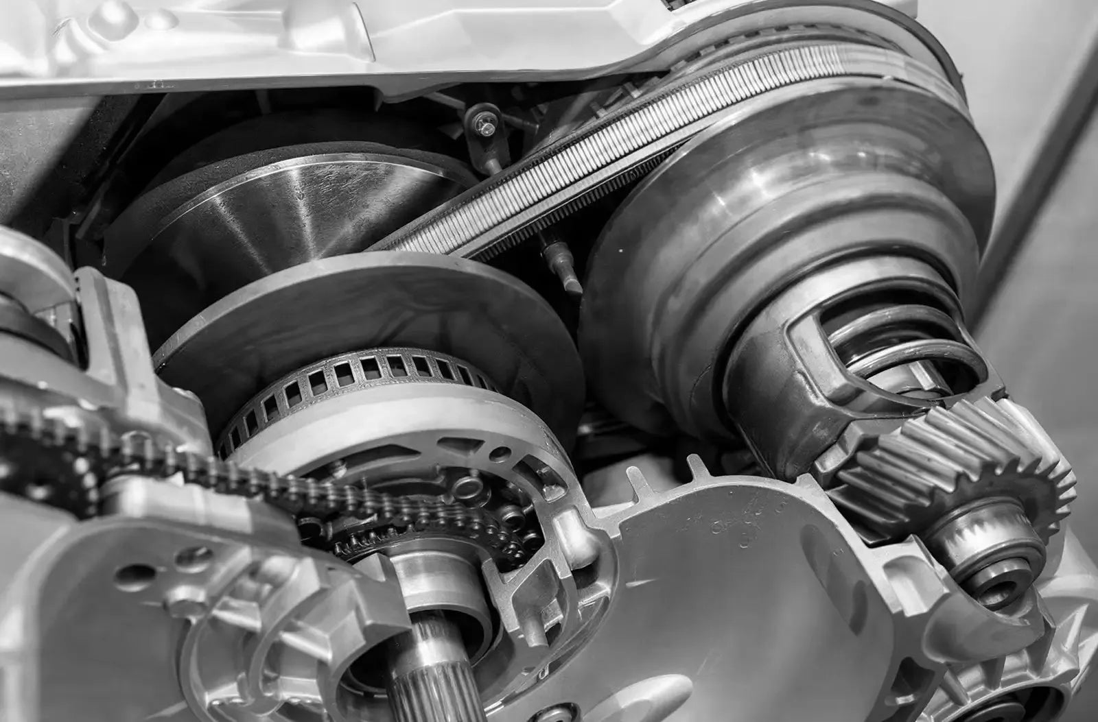 Un esquema técnico detallado en sección transversal que muestra la correa interna, las poleas y los engranajes mecánicos de una transmisión variable continua (CVT).