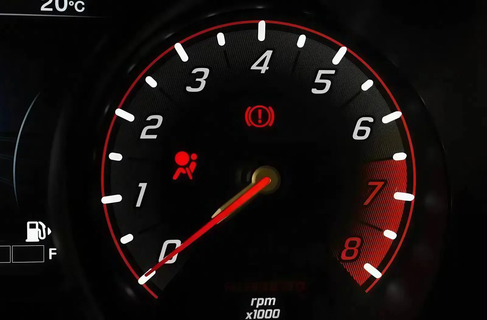 Primer plano del cuadro de instrumentos analógico de un vehículo, con el testigo rojo de seguridad del "Airbag / SRS" prominentemente iluminado.