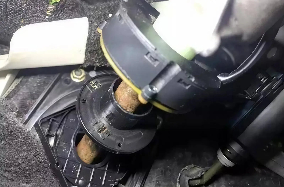 Muestra las manos del conductor sosteniendo un moderno volante multifunción de cuero dentro de un coche estacionado, con el cuadro de instrumentos digital visible al fondo.